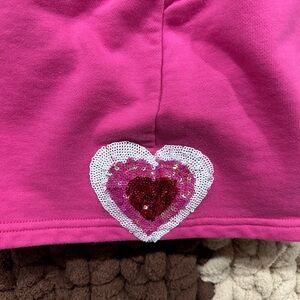QUEEN OF SPARKLES pink elastic waist shorts with sequence hearts on both sides